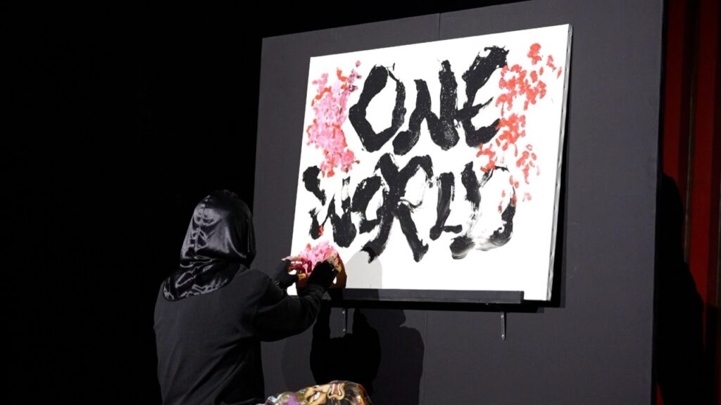 「ONE WORLD」を描き上げる憲真氏の書道パフォーマンス